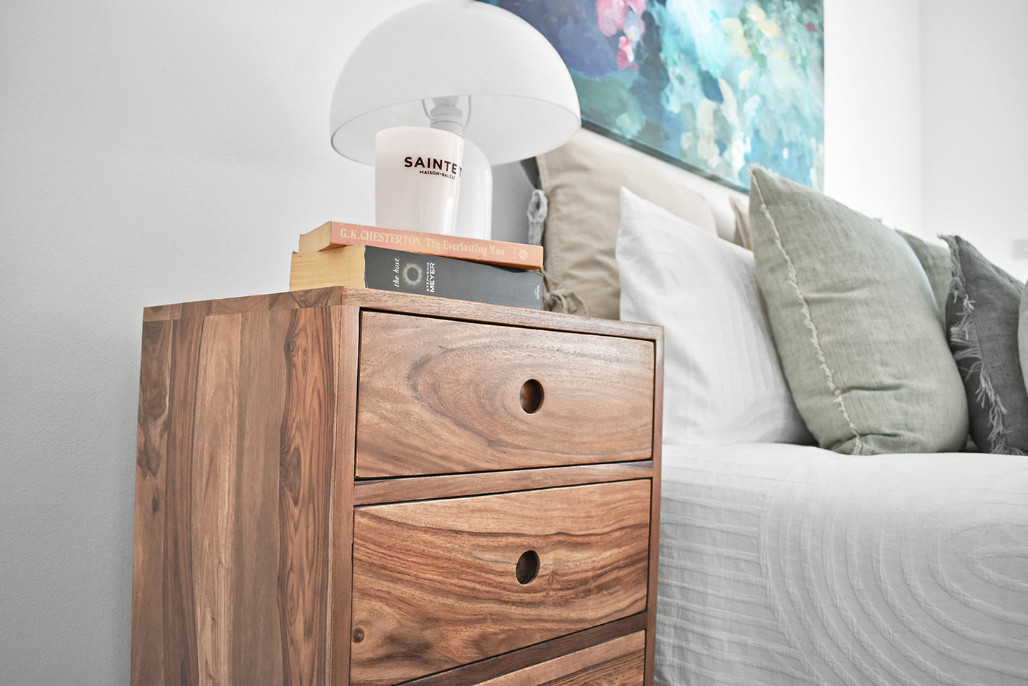 Mid Century Modern Bedside Table in bedroom with books, a candle and light