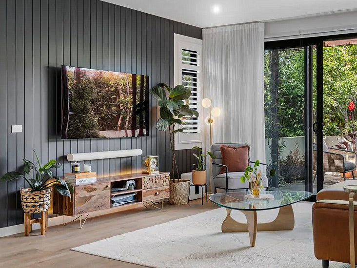 Modern living room with a TV, furniture, and decorative elements.