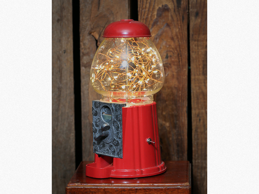 side on red gumball machine lamp with illuminated fairy lights