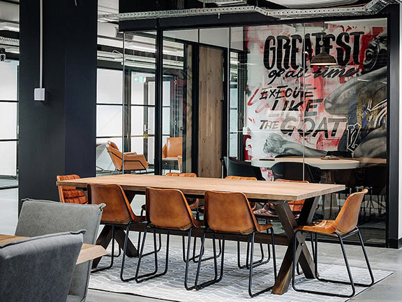8 retro leather chairs around a large table in a creative space