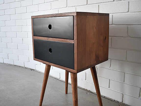 Close up showing rosewood scandinavian bedside table with two black drawers