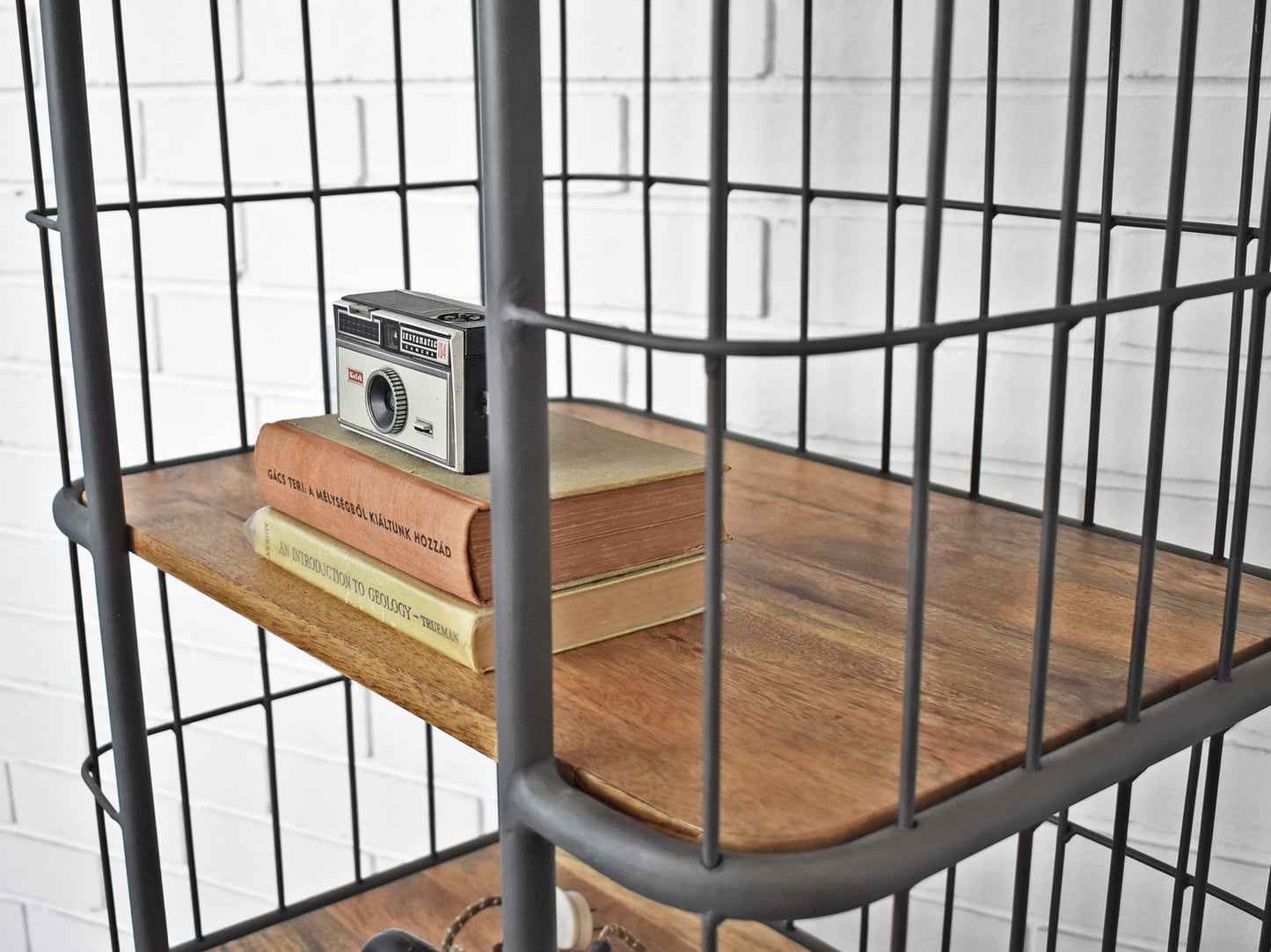 close up of industrial shelf detail with 2 books and camera