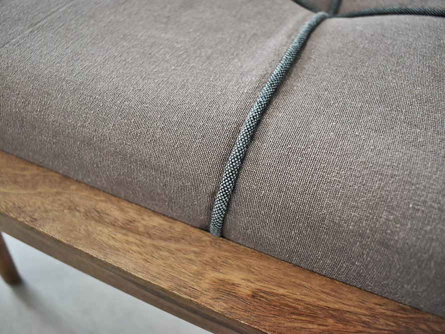 scandi bench close up showing light grey fabric on padding and rosewood frame