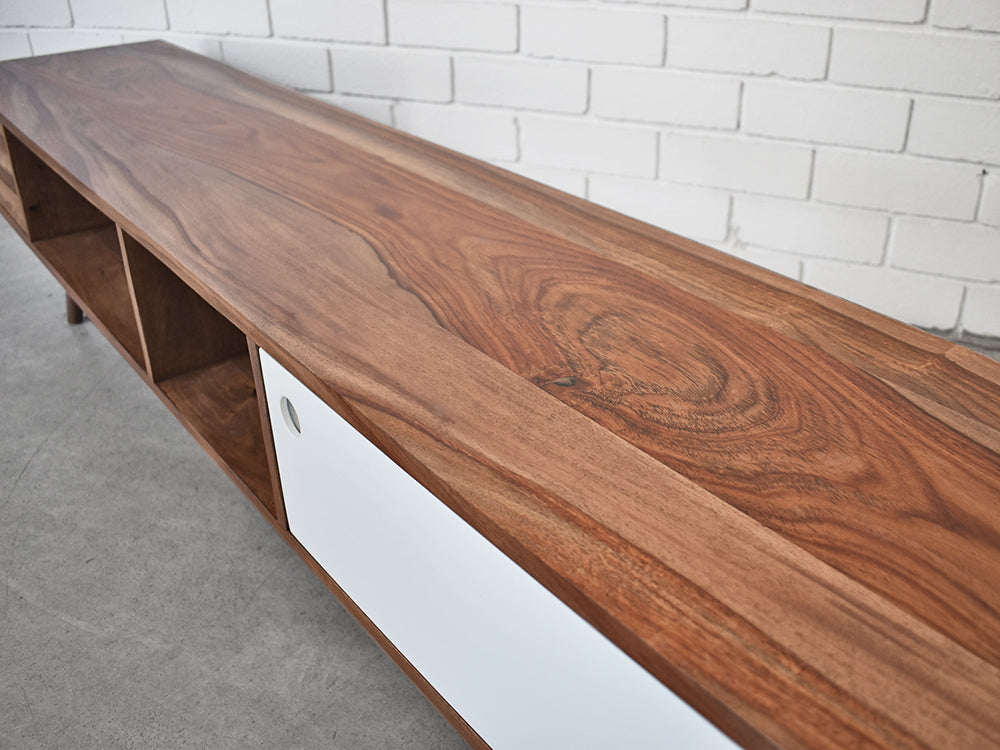 Close up of scandinavian tv entertainment unit, highlighting the top of the unit and its colour and grain. Also the white cupboard door